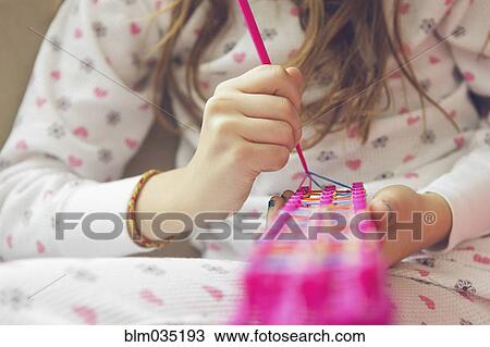 Caucasian girl knitting with rainbow loom View Large Photo Image Stock Image - Caucasian girl knitting with rainbow loom. Fotosearch