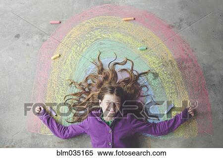 Caucasian girl laying on chalk rainbow View Large Photo Image Stock Photography - Caucasian girl laying on chalk rainbow. Fotosearch