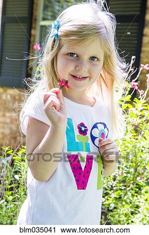 Stock Image - Caucasian girl playing in backyard. Fotosearch