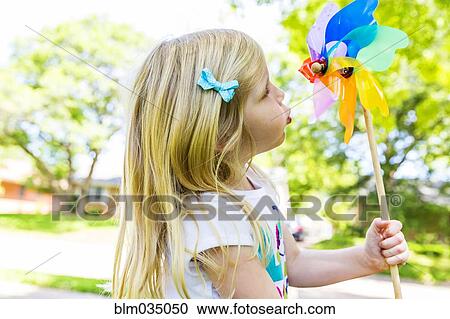 Caucasian girl playing with pinwheel in backyard View Large Photo Image Stock Image - Caucasian girl playing with pinwheel in backyard. Fotosearch