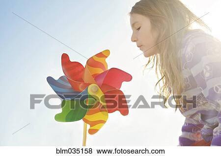 Caucasian girl playing with pinwheel under blue sky View Large Photo Image Stock Photo - Caucasian girl playing with pinwheel under blue sky. Fotosearch