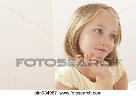 Stock Photo - Caucasian girl resting chin in hand. Fotosearch