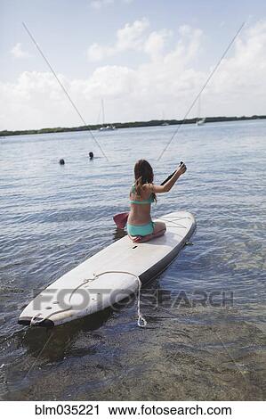 Caucasian girl rowing on paddleboard in lake View Large Photo Image Stock Image - Caucasian girl rowing on paddleboard in lake. Fotosearch