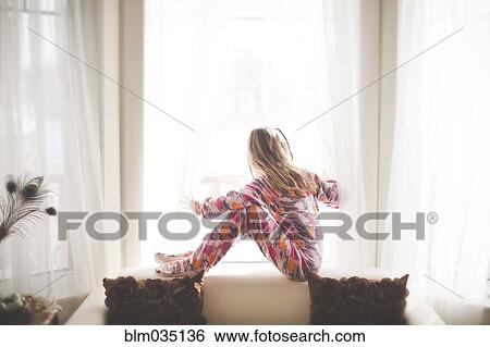 Caucasian girl sitting in window View Large Photo Image Stock Photograph - Caucasian girl sitting in window. Fotosearch