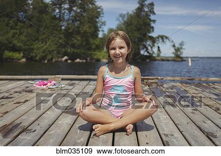 Caucasian girl sitting on wooden dock over lake View Large Photo Image Stock Photo - Caucasian girl sitting on wooden dock over lake. Fotosearch