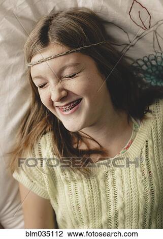 Stock Image - Caucasian girl with braces wearing braid headband. Fotosearch