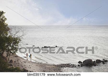 Caucasian girls standing on remote beach View Large Photo Image Stock Photo - Caucasian girls standing on remote beach. Fotosearch