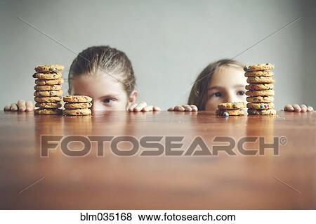 Caucasian girls staring at cookies on table View Large Photo Image Stock Photo - Caucasian girls staring at cookies on table. Fotosearch