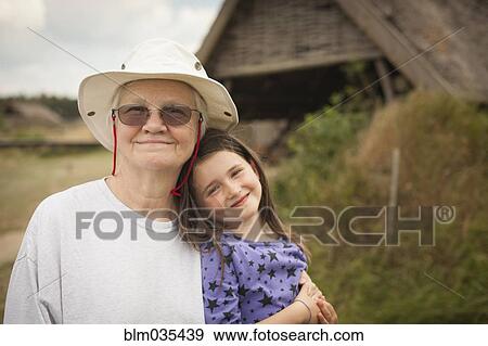 Caucasian grandmother hugging granddaughter in backyard View Large Photo Image Stock Photo - Caucasian grandmother hugging granddaughter in backyard. Fotosearch