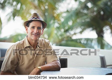 Picture - Caucasian man sitting at patio bar. Fotosearch