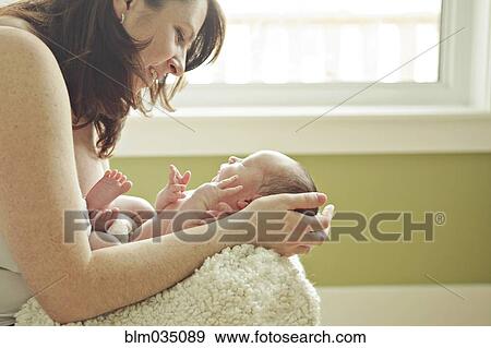 Stock Photo - Caucasian mother holding newborn baby. Fotosearch