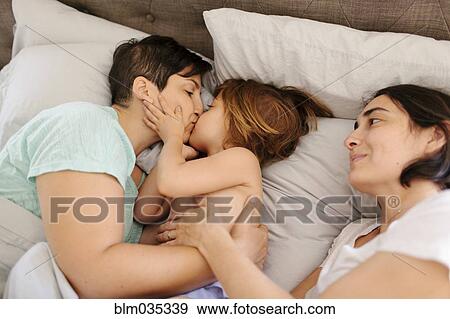 Caucasian mother kissing daughter in bed View Large Photo Image Stock Photo - Caucasian mother kissing daughter in bed. Fotosearch