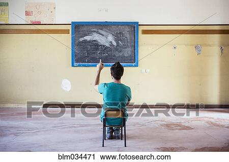 Caucasian student sitting in empty classroom View Large Photo Image Stock Image - Caucasian student sitting in empty classroom. Fotosearch