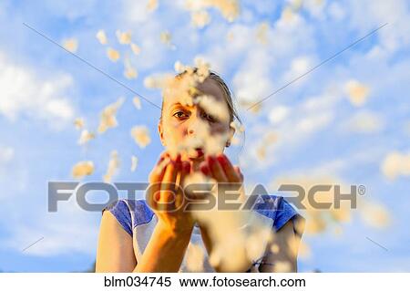 Caucasian teenage girl blowing flower petals under blue sky View Large Photo Image Stock Photography - Caucasian teenage girl blowing flower petals under blue sky. Fotosearch