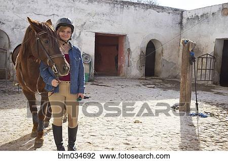 Caucasian teenage girl leading horse in stable on ranch View Large Photo Image Stock Image - Caucasian teenage girl leading horse in stable on ranch. Fotosearch