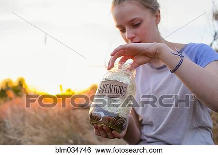 Caucasian teenage girl saving money in jar View Large Photo Image Stock Photograph - Caucasian teenage girl saving money in jar. Fotosearch
