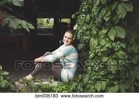 Caucasian teenage girl sitting at ivy wall View Large Photo Image Stock Image - Caucasian teenage girl sitting at ivy wall. Fotosearch