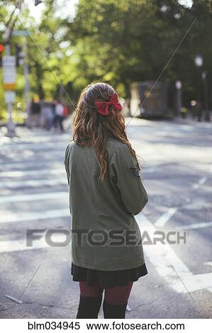 Stock Photography - Caucasian woman crossing city intersection. Fotosearch