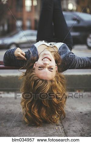 Stock Photo - Caucasian woman laying on city sidewalk. Fotosearch