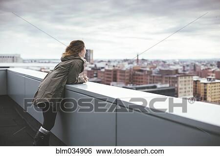 Caucasian woman on urban rooftop admiring cityscape View Large Photo Image Stock Photograph - Caucasian woman on urban rooftop admiring cityscape. Fotosearch