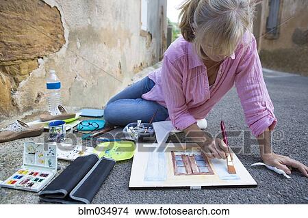 Picture - Caucasian woman painting on concrete ground. Fotosearch