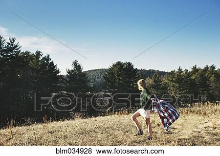 Stock Photo - Caucasian woman playing with scarf on rural hilltop. Fotosearch