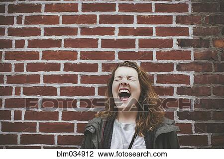 Caucasian woman shouting at brick wall View Large Photo Image Stock Image - Caucasian woman shouting at brick wall. Fotosearch