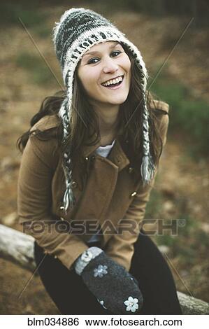 Stock Photograph - Caucasian woman sitting on wooden log. Fotosearch
