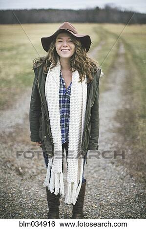 Caucasian woman smiling on dirt path in rural field View Large Photo Image Stock Photograph - Caucasian woman smiling on dirt path in rural field. Fotosearch