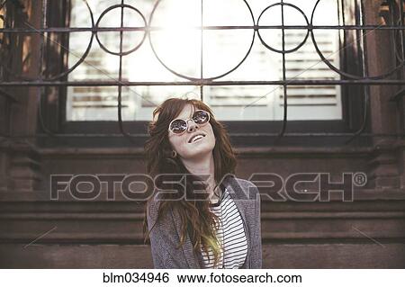 Stock Photograph - Caucasian woman standing under window. Fotosearch
