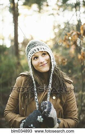 Stock Image - Caucasian woman wearing knitted cap in park. Fotosearch