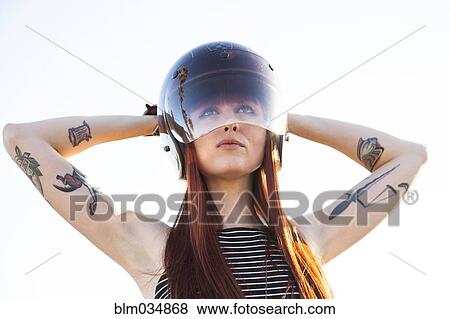 Stock Photo - Caucasian woman wearing motorcycle helmet. Fotosearch