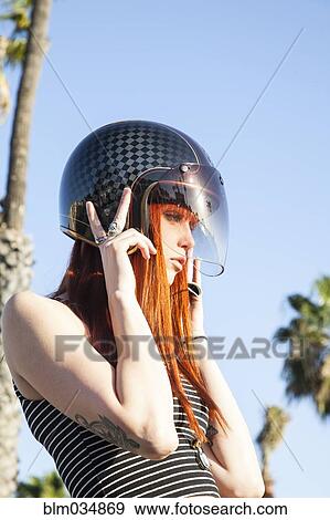 Stock Photo - Caucasian woman wearing motorcycle helmet. Fotosearch