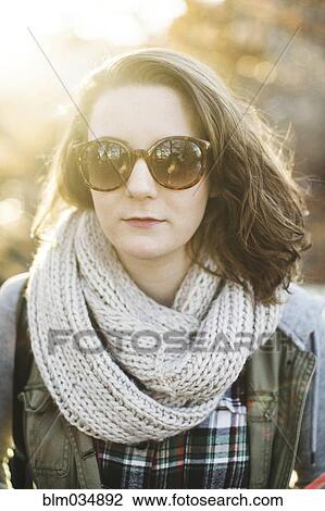 Stock Image - Caucasian woman wearing sunglasses and scarf. Fotosearch
