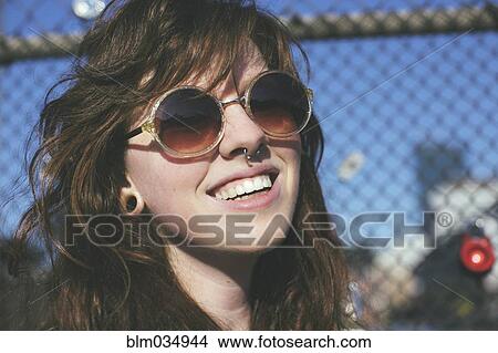 Caucasian woman wearing sunglasses at fence View Large Photo Image Picture - Caucasian woman wearing sunglasses at fence. Fotosearch