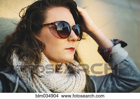 Picture - Caucasian woman wearing sunglasses outdoors. Fotosearch