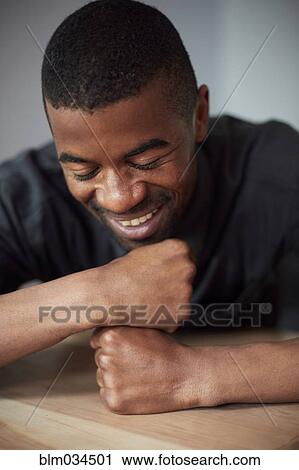 Close up of Black man resting chin on fists View Large Photo Image Stock Image - Close up of Black man resting chin on fists. Fotosearch