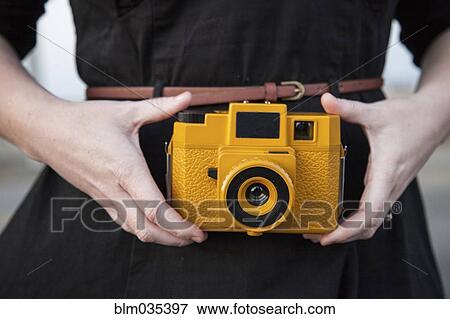 Close up of Black woman holding plastic camera View Large Photo Image Stock Photo - Close up of Black woman holding plastic camera. Fotosearch
