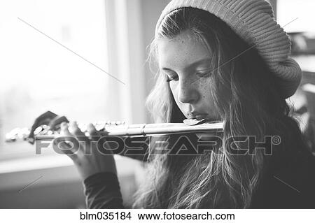 Picture - Close up of Caucasian girl playing flute. Fotosearch