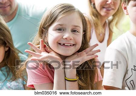 Close up of Caucasian girl smiling with family View Large Photo Image Stock Photograph - Close up of Caucasian girl smiling with family. Fotosearch