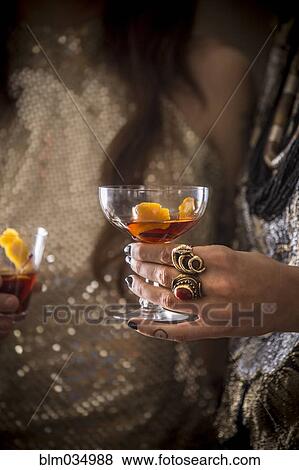 Stock Photo - Close up of Caucasian women drinking cocktails. Fotosearch