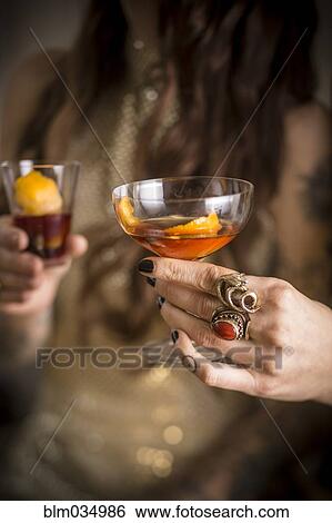 Stock Photograph - Close up of Caucasian women drinking cocktails. Fotosearch