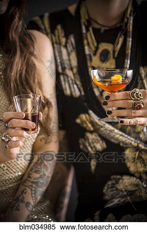 Stock Photography - Close up of Caucasian women drinking cocktails. Fotosearch