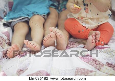 Close up of feet of siblings on blanket View Large Photo Image Stock Image - Close up of feet of siblings on blanket. Fotosearch