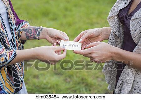 Picture - Close up of friends holding sweet love card. Fotosearch