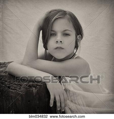 Stock Image - Close up of girl leaning on tree stump. Fotosearch