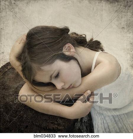 Stock Image - Close up of girl leaning on tree stump. Fotosearch