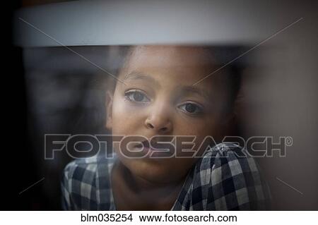 Picture - Close up of wistful girl looking out window. Fotosearch