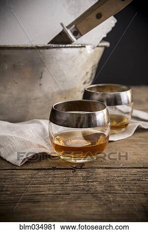 Stock Image - Cocktail glasses and ice block on table. Fotosearch