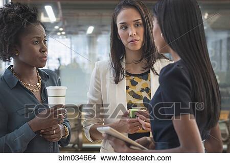 Picture - Concerned businesswomen talking in office. Fotosearch